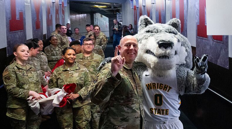Rowdy Raider Wright State mascot and Col. Patrick Miller, 88th Air Base Wing and installation commander, pose with Airmen on March 16 before they carried a large American flag out onto the floor of University of Dayton Arena for the opening ceremony of the NCAA men’s basketball tournament game between Wright State and Bryant. Wright State went on to win the game and advance to the next round of tournament play. U.S. AIR FORCE PHOTO/R.J. ORIEZ