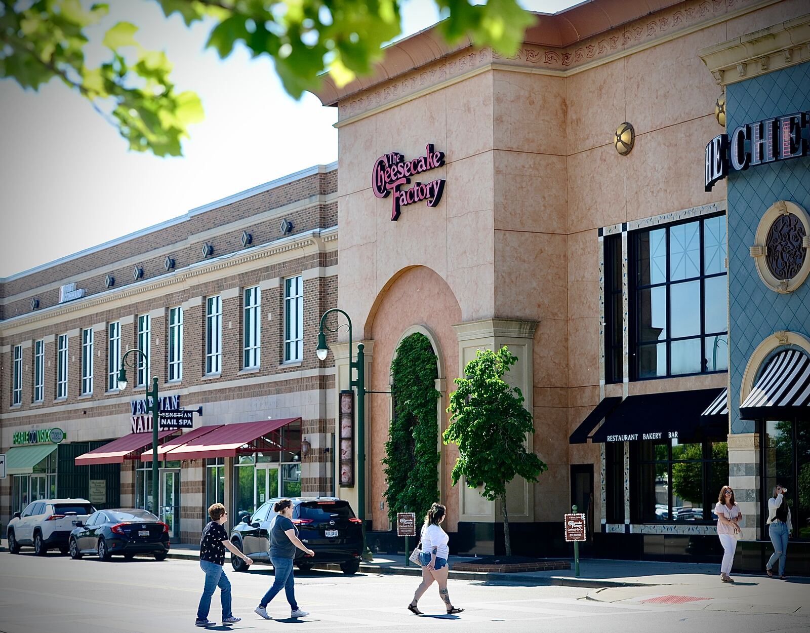 Pedestrians walk near the Cheesecake Factory restaurant at The Greene Town Center in Beavercreek on Tuesday, May 16, 2024. MARSHALL GORBY / STAFF