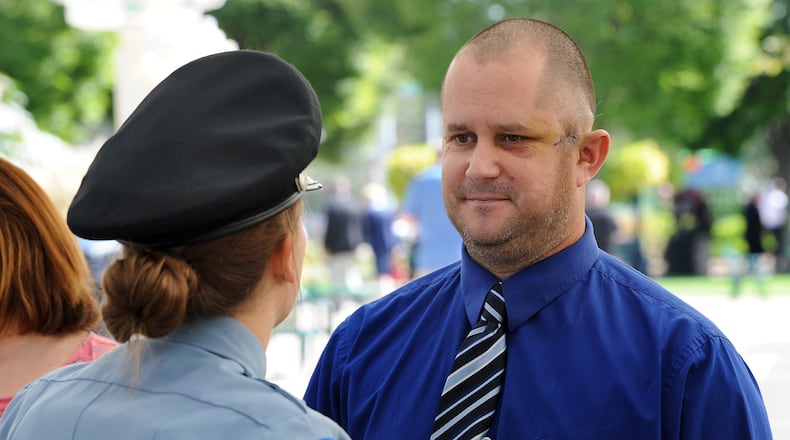 Dayton Police Officer Thadeu Holloway, talks with other officers during the Montgomery County 14th Annual Law Enforcement Memorial Ceremony Monday Sept. 27, 2021. Holloway, an eight-year veteran of the Dayton Police Department, was shot in the left side of his face during a struggle with a suspect the previous week.  MARSHALL GORBY\STAFF