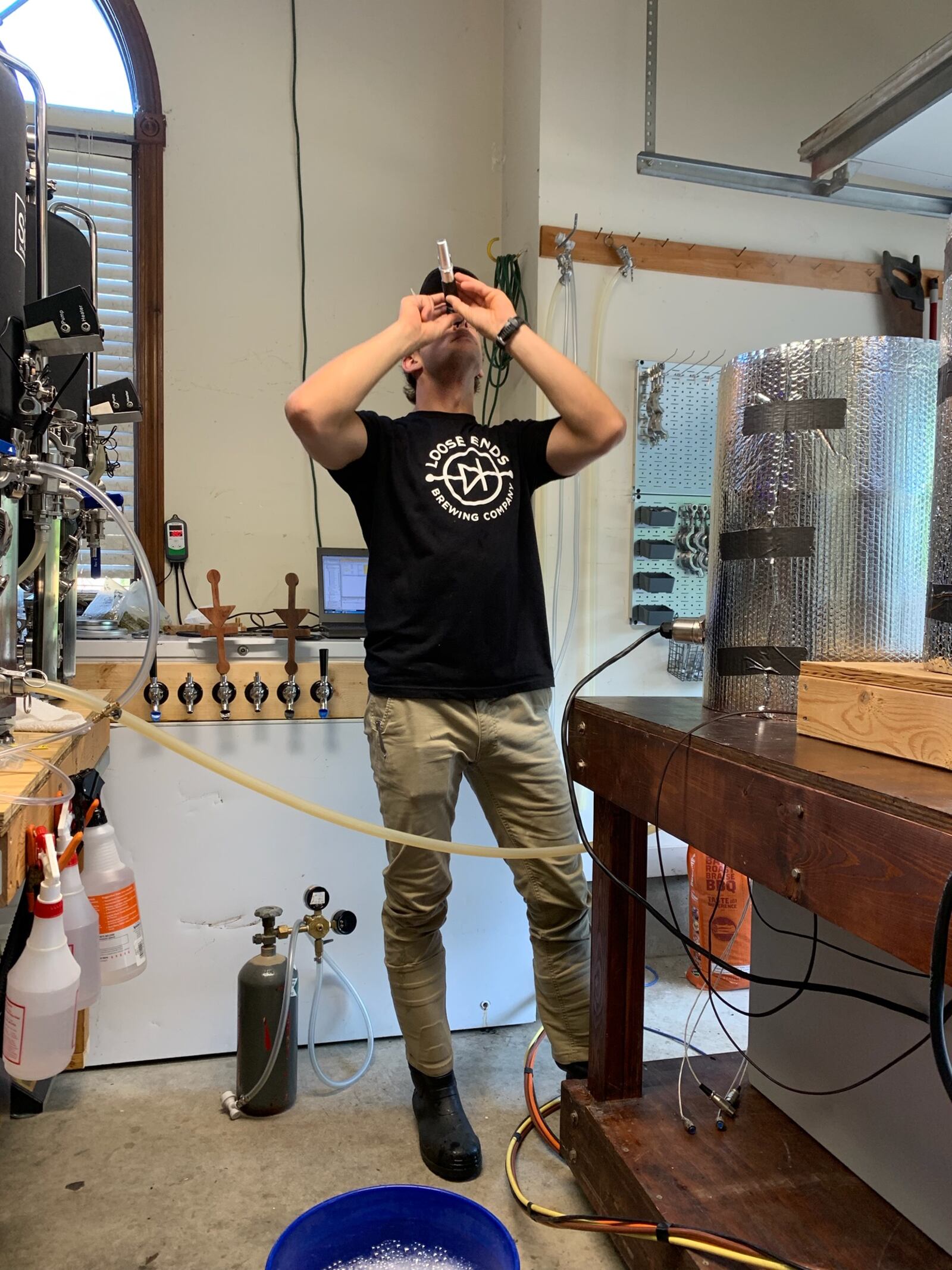 John Loose, co-founder of Loose Ends Brewing Co., uses a refractometer to check the sugar content of a future beer. The brewery is gearing up to open this spring in south Centerville.