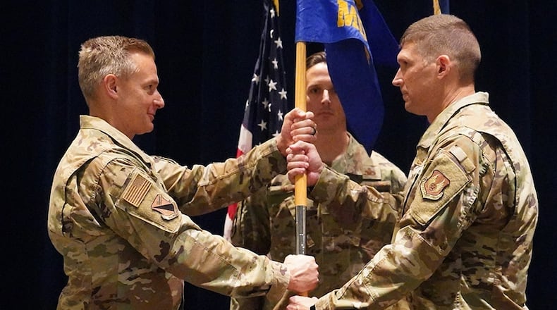 Col. Christian Lyons (left), 88th Medical Group commander, passes the 88th Medical Support Squadron guidon to Lt. Col. Damian Pardue during a change of command ceremony June 24 at Wright-Patterson Medical Center. He assumes command from Lt. Col. Matthew Gross , who’s leaving for MacDill Air Force Base, Florida, to become deputy planner for Special Operations Command Central Readiness. U.S. AIR FORCE PHOTO/KENNETH STILES