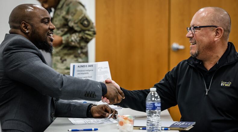Alonzo Davis, left, shakes hands with regional operation manager of Gem City Tire Garry Harness at the office of reentry's reverse career fair held at the job center Wednesday March 27, 2024. JIM NOELKER/STAFF