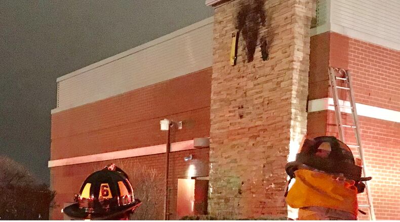 Troy fire crews look at a sign on the side of McDonald’s on W. Main St. after an electrical short caused a fire.