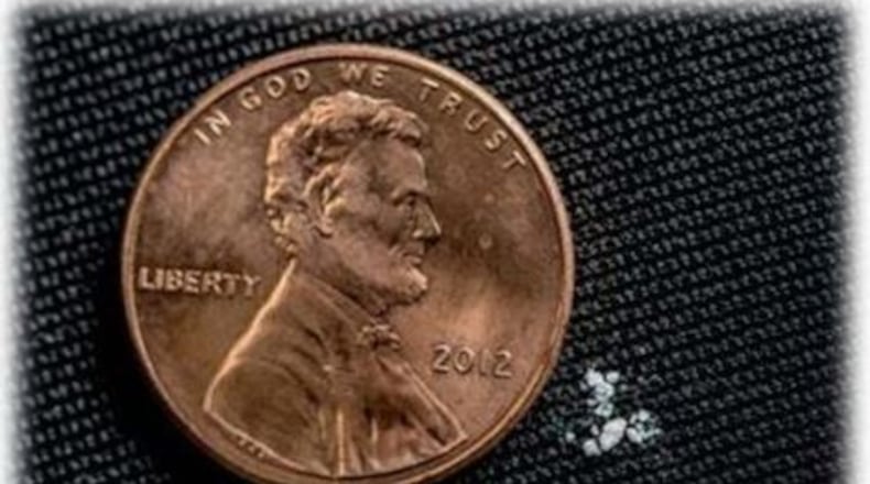 Government officials say 2-3 milligrams of fentanyl — shown next to a penny for reference — can be a fatal dose. Post office inspectors recently discovered 1,500 tablets of a fentanyl analogue addressed to a Dayton residence. DEA PHOTO
