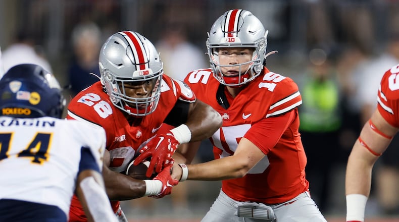 Ohio State quarterback Devin Brown, right, hands off to running back T.C. Caffey during the second half of the team's NCAA college football game against Toledo on Saturday, Sept. 17, 2022, in Columbus, Ohio. (AP Photo/Jay LaPrete)