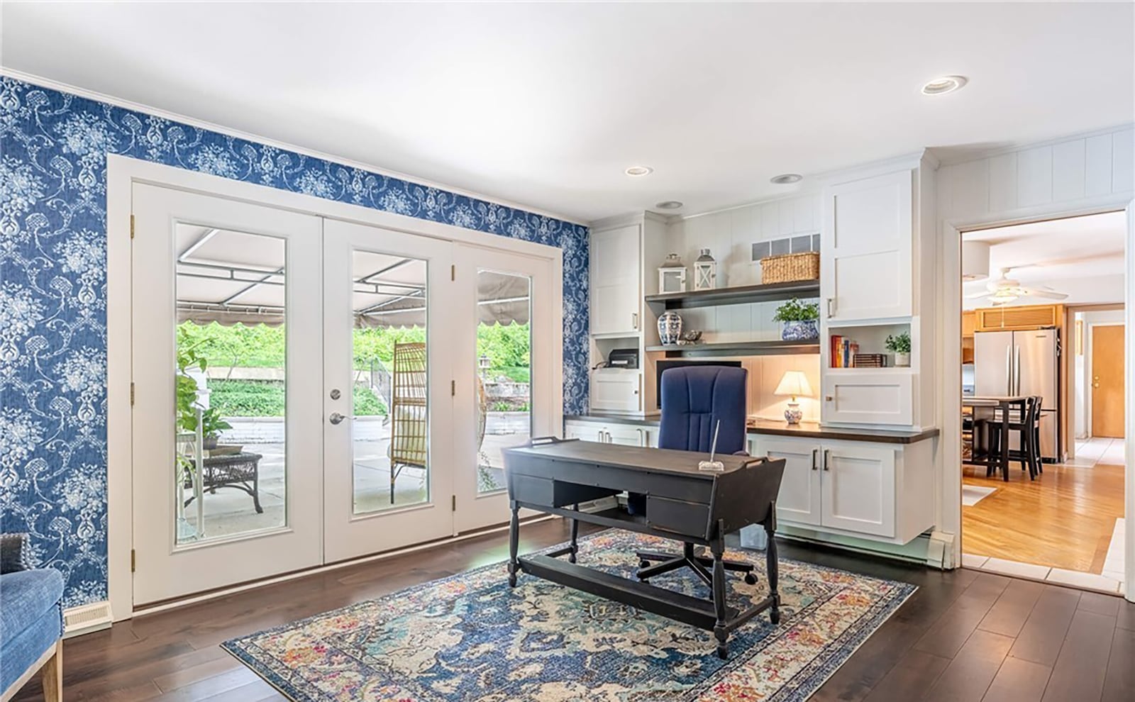 The home office has a built in desk and cabinets, hardwood flooring and an exterior door leading out to the back patio partially covered with an awning. CONTRIBUTED