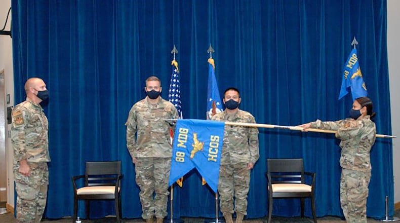 Senior Master Sgt. Queen Aric presents the new 88 Healthcare Operations Squadron flag with assistance from Senior Master Sgt. Benjamin Seekell while Col. Christian Lyons, 88th Medical Group commander, and Lt. Col. Cang Bui, squadron commander observe Oct. 1. CONTRIBUTED PHOTO