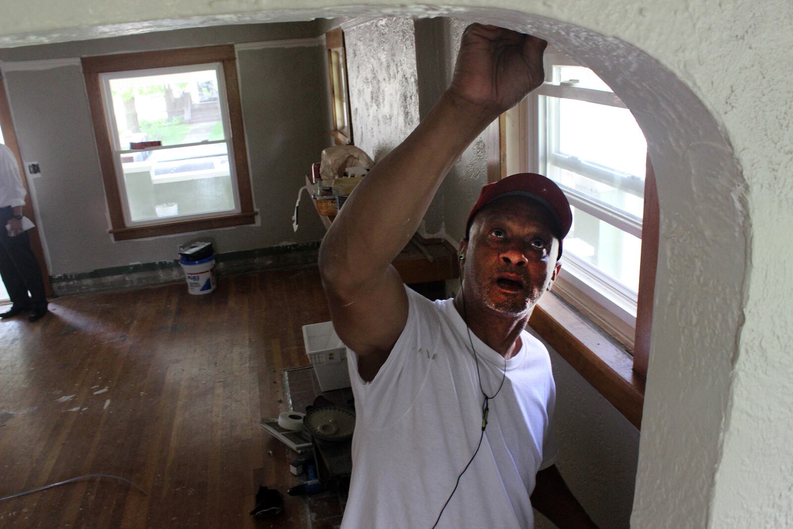 Andre Waggoner, who works for New Beginning Construction, paints the inside of a rehabbed home on West Worley Avenue in Trotwood. BYRON STIRSMAN / STAFF