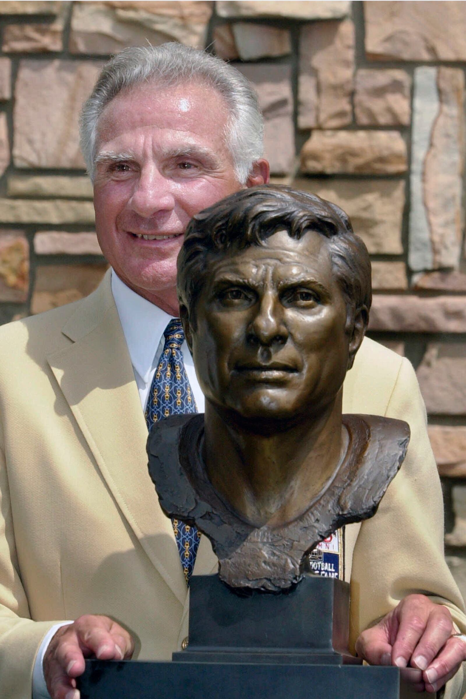 FILE - Former Miami Dolphins great Nick Buoniconti holds his bronze bust after enshrinement into the Pro Football Hall of Fame in Canton, Ohio, Aug. 4, 2001. (AP Photo/Mark Duncan)