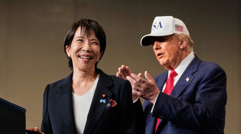 FILE - Japanese Prime Minister Sanae Takaichi, left, with President Donald Trump, reacts as she was speaking to members of the military aboard the USS George Washington, an aircraft carrier docked at an American naval base, in Yokosuka, Tuesday, Oct. 28, 2025. (AP Photo/Mark Schiefelbein, File)