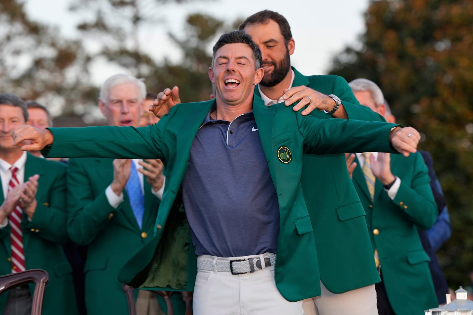 Scottie Scheffler puts the green Jacket on winner, Rory McIlroy, of Northern Ireland, at the Masters golf tournament, Sunday, April 13, 2025, in Augusta, Ga. (AP Photo/David J. Phillip)