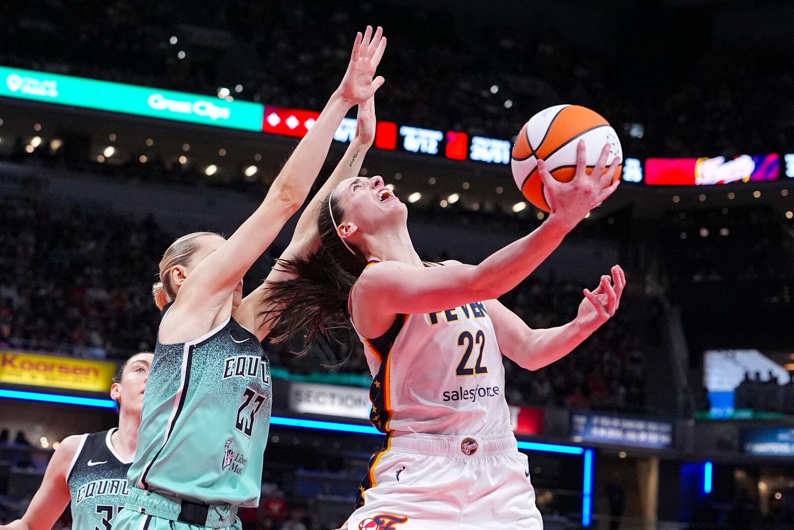 Indiana Fever guard Caitlin Clark (22) shoots over New York Liberty guard Marine Johannes (23) in the second half of a WNBA basketball game in Indianapolis, Saturday, May 24, 2025. (AP Photo/Michael Conroy)