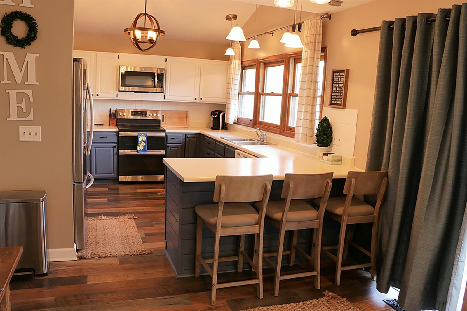 The kitchen and breakfast room were updated with wood-laminate flooring, painted cabinetry, appliances and lighting. A sliding patio door opens from the breakfast room to the rear deck and patio. CONTRIBUTED PHOTO BY KATHY TYLER