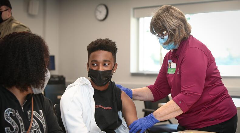 Roosevelt Jackson, 14, gets his dose of the COVID-19 vaccine on Saturday, May 15 at Dayton Children's Hospital, while his mom, Kellye Jackson, looks on. Courtesy of Dayton Children's Hospital.