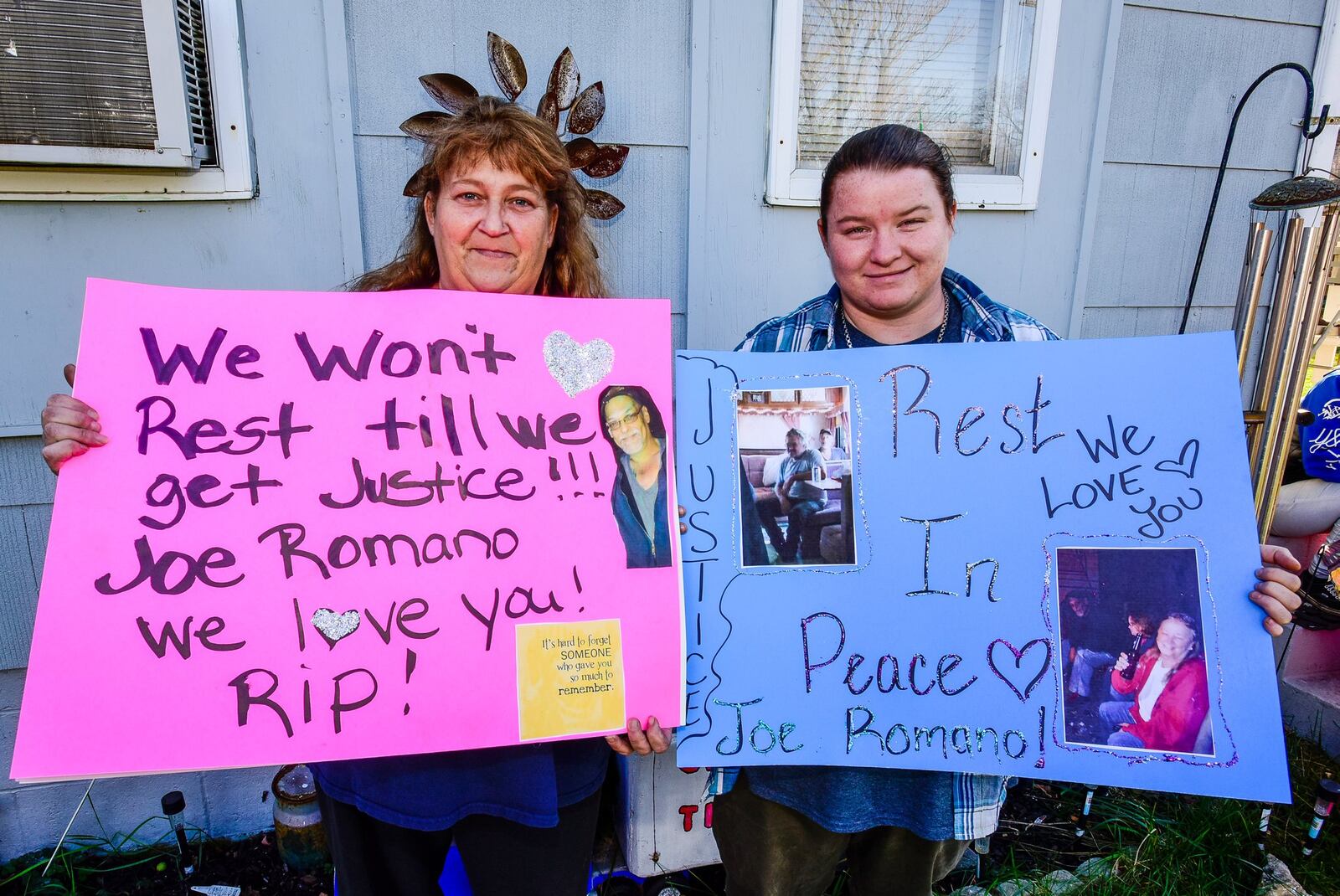 Teresa Vick, left, and her daughter Meghan Bray hold signs they made to honor Joe Romano, who was shot to death in his Lafayette Avenue home Nov. 4. Vick is organizing a candlelight vigil for Romano to take place Saturday night in front of his home. NICK GRAHAM/STAFF