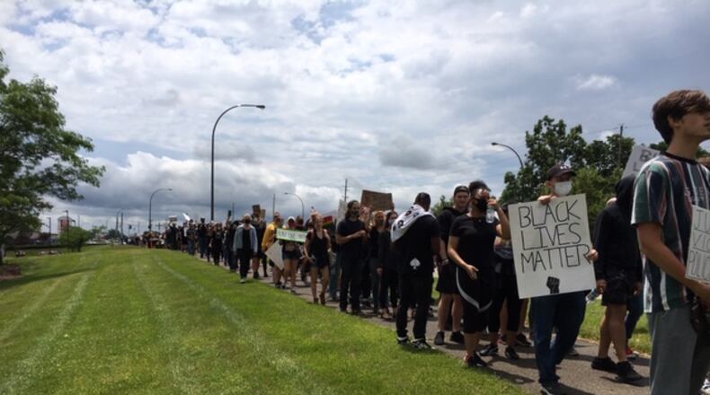 Protestors marching north on North Fairfield Road Saturday afternoon in Beavercreek. THOMAS GNAU/STAFF