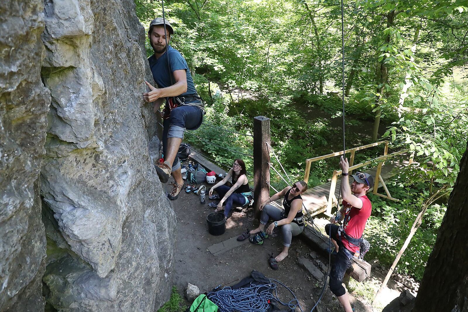 Jackson Pope works his way up a limestone cliff as he and his friends, from left, Emily Andrews, Mallory Hutton and Michael Barr rock climb at Mad River Gorge Tuesday. BILL LACKEY/STAFF