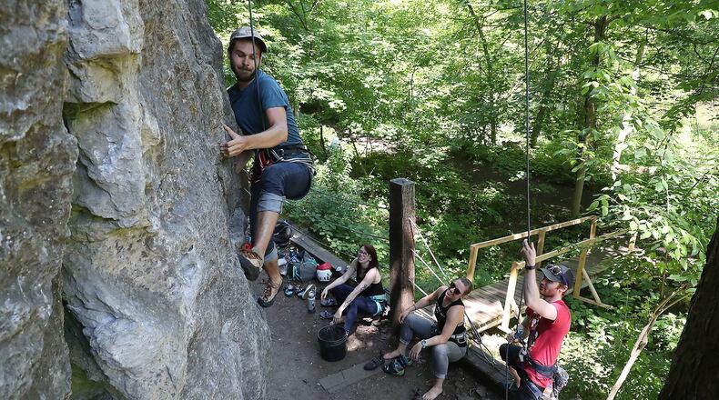 Jackson Pope works his way up a limestone cliff as he and his friends, from left, Emily Andrews, Mallory Hutton and Michael Barr rock climb at Mad River Gorge. BILL LACKEY/STAFF