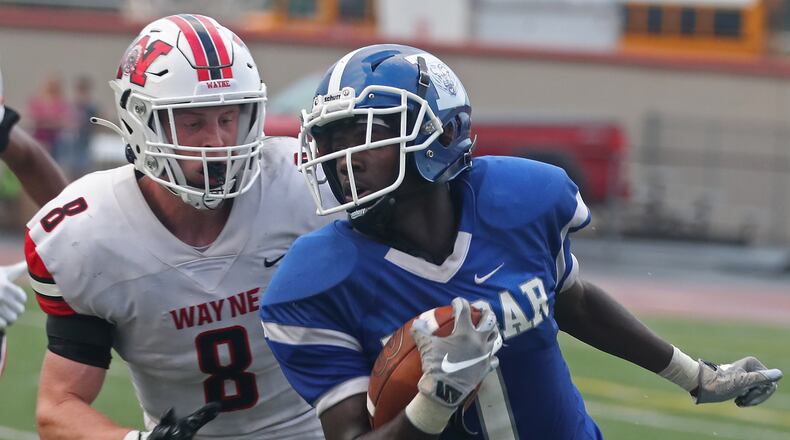 Dunbar's Darian Leslie tries to avoid Wayne linebacker Adam Trick during on Friday, Aug. 20, 2021. Trick on Wednesday signed to play collegiately at Miami. BILL LACKEY/STAFF