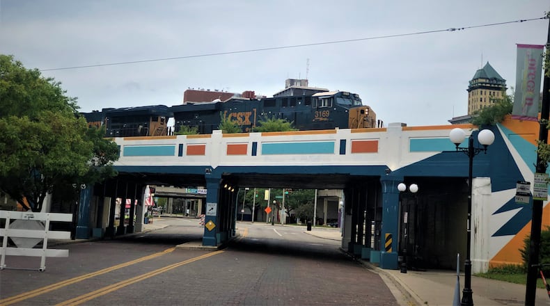 A CSX commercial train crosses an overpass in the Oregon District in Dayton. Dayton hasn't had passenger rail since 1979. CORNELIUS FROLIK / STAFF