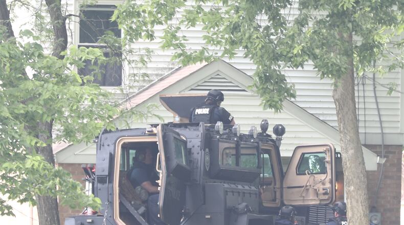 Members of the Springfield Police Division surround a house on South Lowry Avenue Monday, June 6, 2022. BILL LACKEY / STAFF