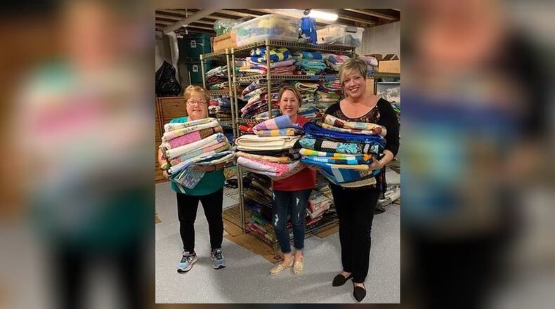 Debbie Goldshot (center) and other volunteers with Gold Heart Quilters Inc. have donated hundreds of quilts and personal protective equipment to Dayton-area organizations. CONTRIBUTED