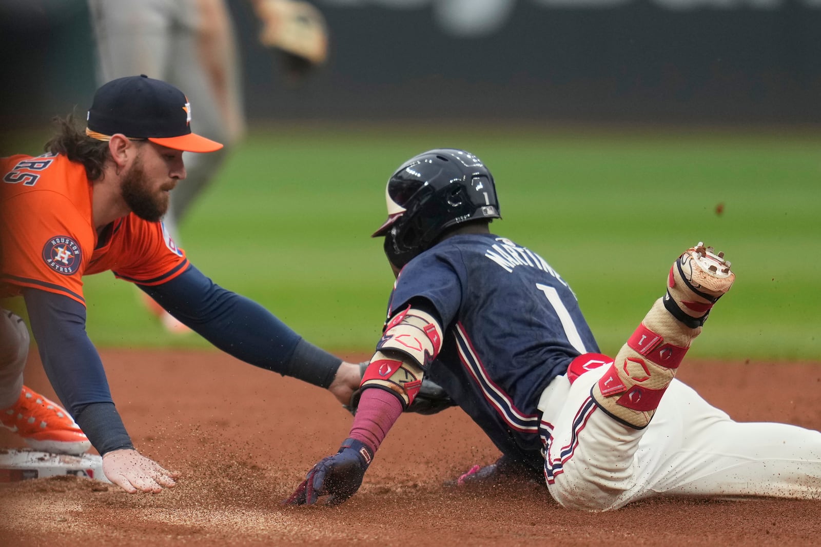 Houston Astros second baseman Brendan Rodgers, left, tags out Cleveland Guardians' Angel Martinez (1) at second base in the first inning of a baseball game in Cleveland, Friday, June 6, 2025. (AP Photo/Sue Ogrocki)