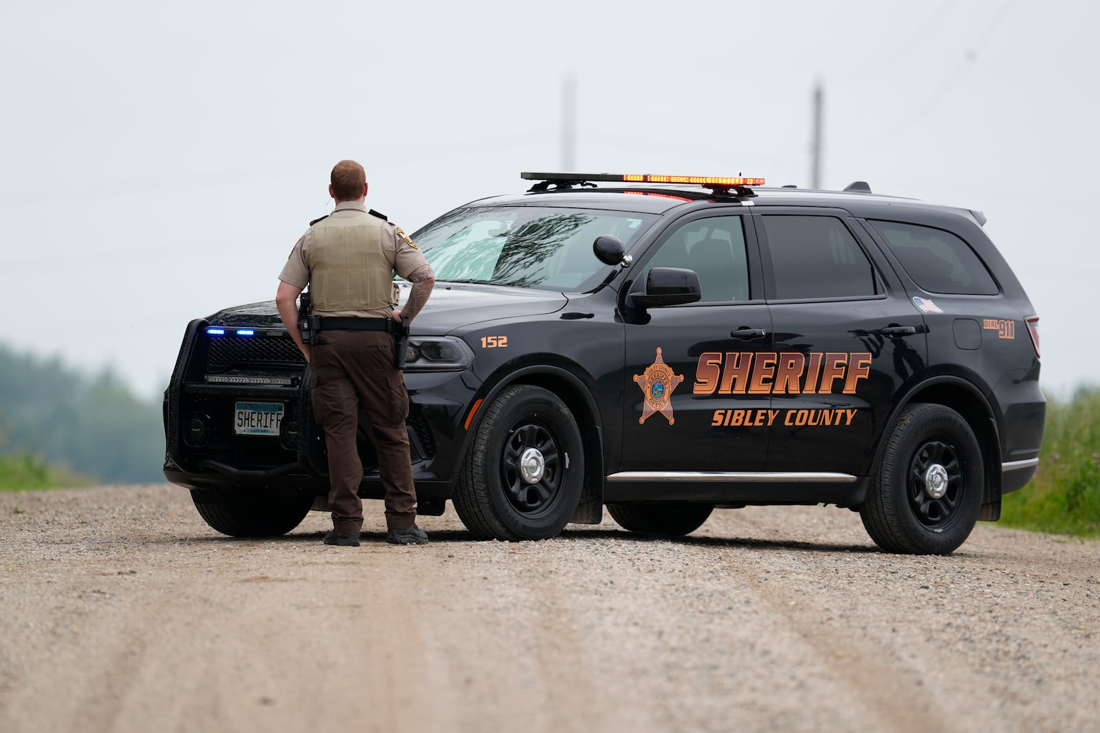 A Sibley County Sheriff's Deputy blocks the road where the suspect involved in the shooting of two state lawmakers vehicle was found Sunday, June 15, 2025, in Faxon Township, Minn. (AP Photo/George Walker IV)