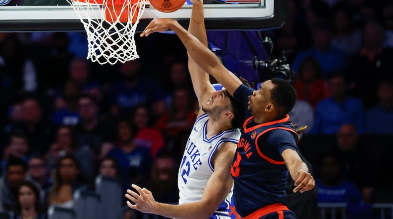 Virginia center Ugonna Onyenso, right, alters shot by Duke forward Cameron Boozer during the second half of an NCAA college basketball game in the championship of the Atlantic Coast Conference tournament in Charlotte, N.C., Saturday, March 14, 2026. (AP Photo/Nell Redmond)