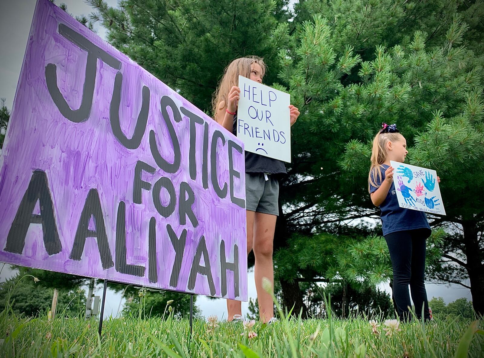 A protest over the handling of complaints in connection to Aaliyah Artis, a 12-year old girl who died in Xenia in June, took place on front of Greene County Children Services Tuesday.  Wearing a bow, Joezie Jobes, and Lily Redmond, hold signs at the protest. MARSHALL GORBY\STAFF