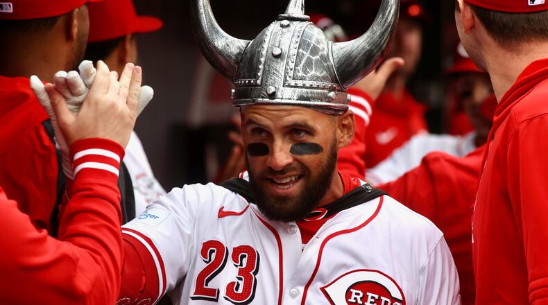 Nick Martini, of the Reds, celebrates with teammates in the dugout after hitting a two-run home run in the second inning on Opening Day on Thursday, March 28, 2024, at Great American Ball Park in Cincinnati. David Jablonski/Staff