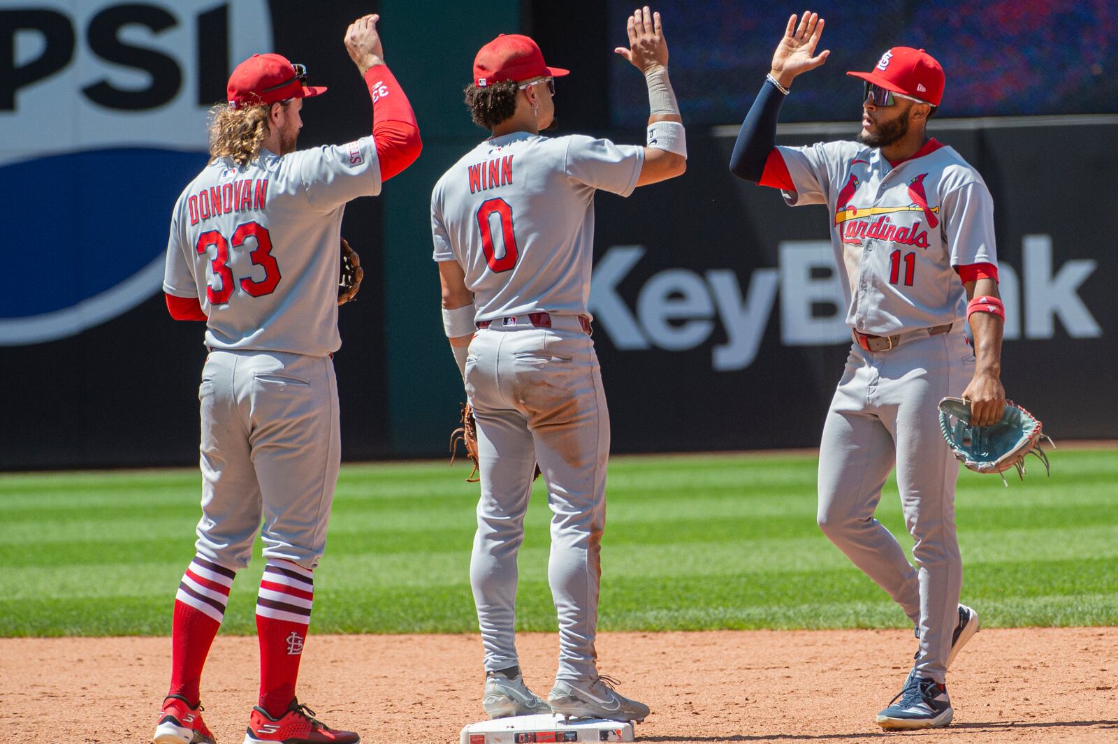 St. Louis Cardinals' Masyn Winn (0) and Brendan Donovan (33) greet Victor Scott II (11) at the end of a baseball game against the Cleveland Guardians, Sunday, June 29, 2025, in Cleveland. (AP Photo/Phil Long)