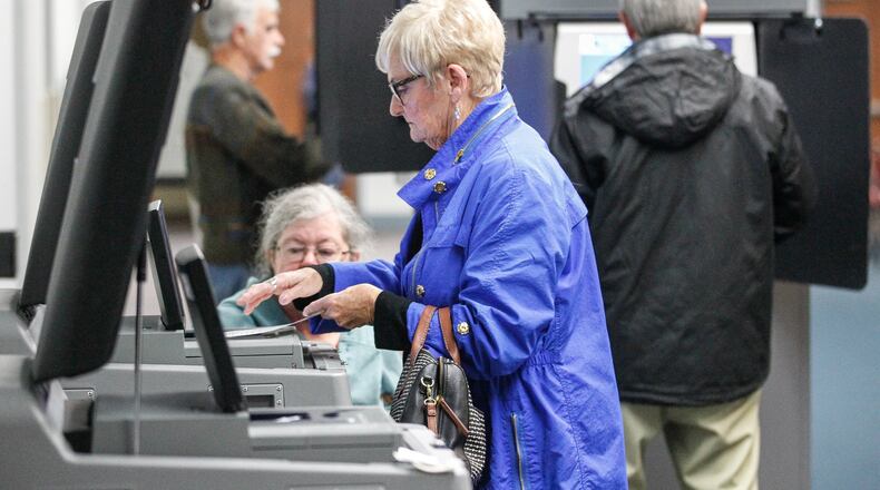 Brenda Netzley of Washington Twp. feeds her paper ballot into a scanner voting at the Washington Twp. Recreation Center for the first time on new equipment purchased by Montgomery County. CHRIS STEWART / STAFF