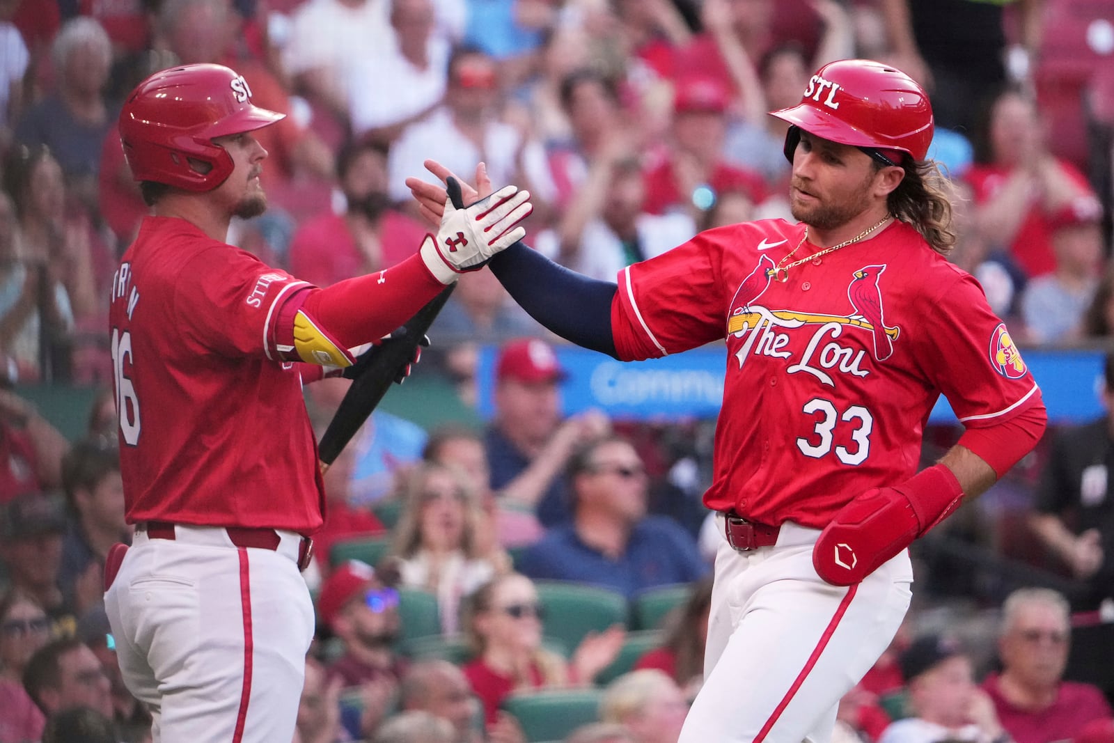St. Louis Cardinals' Brendan Donovan (33) is congratulated by teammate Nolan Gorman after scoring during the third inning of a baseball game against the Cincinnati Reds Friday, June 20, 2025, in St. Louis. (AP Photo/Jeff Roberson)