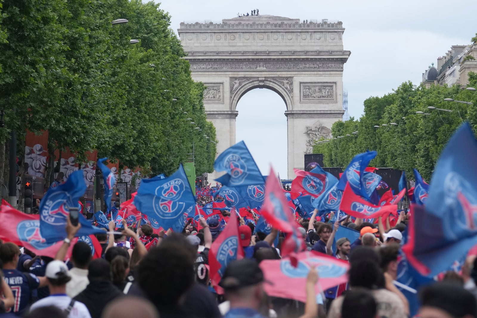 PSG supporters invade the Champs-Elysees avenue, with de Arc de Triomphe in background, before a PSG players' parade after the team won the Champions League final soccer match between Paris Saint-Germain and Inter Milan Sunday, June 1, 2025 in Paris. (AP Photo/Thibault Camus)