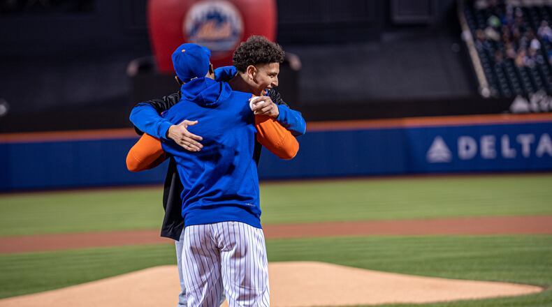 Koby Brea gets a hug from Starling Marte after throwing out the first pitch before a New York Mets game on Tuesday, Sept. 27, 2022, at Citi Field in Queens, N.Y. Photo by Ryan Phillips