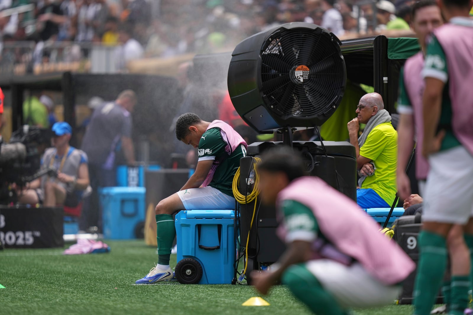 FILE - Palmeiras' Vitor Roque sits on the side of the pitch in a cooling mist after being substituted during the Club World Cup round of 16 soccer match between Palmeiras and Botafogo in Philadelphia, Sunday, June 29, 2025. (AP Photo/Matt Slocum, File)