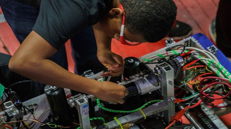 A student fine-tunes a robot in preparation for the next match. The Wright-Patterson Air Force Base Education Outreach Office works with the FIRST Robotics Competition in which high school students strategize, prototype, manufacture, assemble and program a 125-pound robot in only six weeks. This program not only supports education in science, technology, engineering and math, but improves aware of opportunities to pursue STEM fields. (U.S. Air Force photo/Kwame Acheampong)