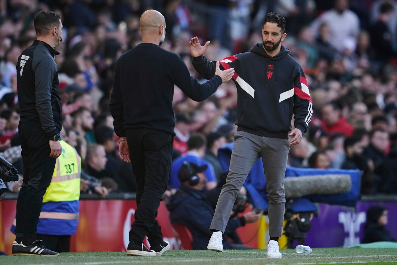 Manchester City's head coach Pep Guardiola, left, and Manchester United's head coach Ruben Amorim shake hands after the English Premier League soccer match between Manchester City and Manchester United in Manchester, England, Sunday, April 6, 2025. (AP Photo/Dave Thompson)