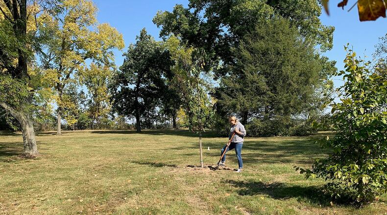 Twenty-two white flowering trees are planted as part of an Arbor Day celebration on the grounds of the Wright Brothers Memorial Oct. 5. Danielle Trevino, 88th Civil Engineer biological scientist, helps plant the trees in an effort to help create a space that can be enjoyed for generations. CONTRIBUTED PHOTO
