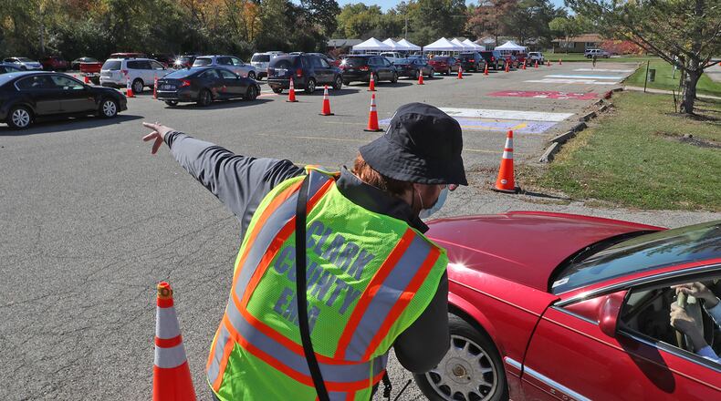 Kyle Trout, communications coordinator for the Clark County Combined Health District, directs traffic during a free drive-thru COVID-19 testing clinic Oct. 16, 2020, in the parking lot of Kenton Ridge High School. BILL LACKEY/STAFF