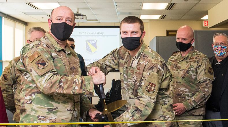 Col. Patrick Miller (left), 88th Air Base Wing commander, and Maj. Hollis Troxel, 88th Operations Support Squadron director of operations, cut the ribbon during the official opening of the Follow-On Skills Training facility Nov. 3 at Wright-Patterson Air Force Base. The airfield operations officer training center is the first of four to open across the Air Force to standardize and accelerate the program. U.S. AIR FORCE PHOTO/JAIMA FOGG