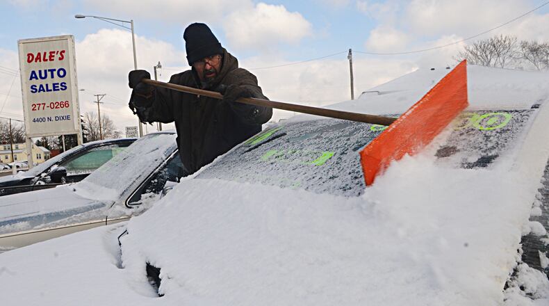 Bitter cold will dip thermometers this weekend before an Alberta clipper brings in snow late Monday. Here, James Mylo removes snow Thursday morning, Feb. 9, 2017, from the cars at Dale’s Auto Sales located at 4400 North Dixie. MARSHALL GORBY / STAFF