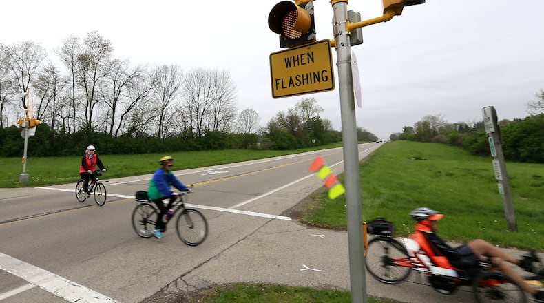 A group of bicylists wait for traffic before crossing US 68 in Clark County on the bike path in this file photo. Bill Lackey/Staff