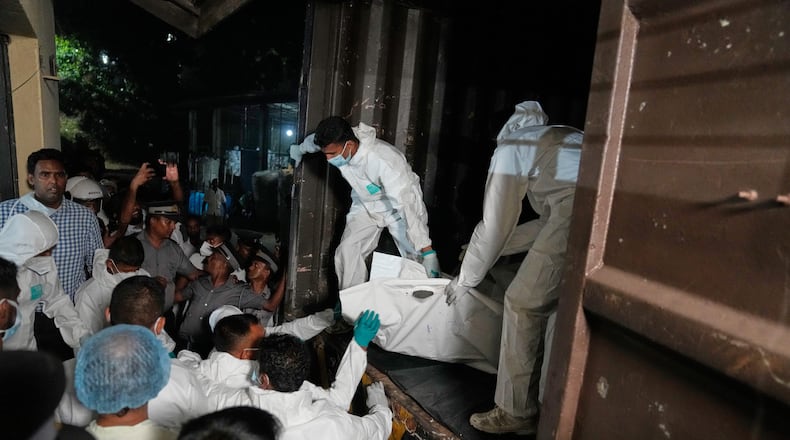 Healthcare workers unload from a vehicle, the bodies of Iranian sailors who died when their IRIS Dena warship sank outside Sri Lanka's territorial waters, in Galle, Sri Lanka, Wednesday, March 4, 2026. (AP Photo/Eranga Jayawardena)