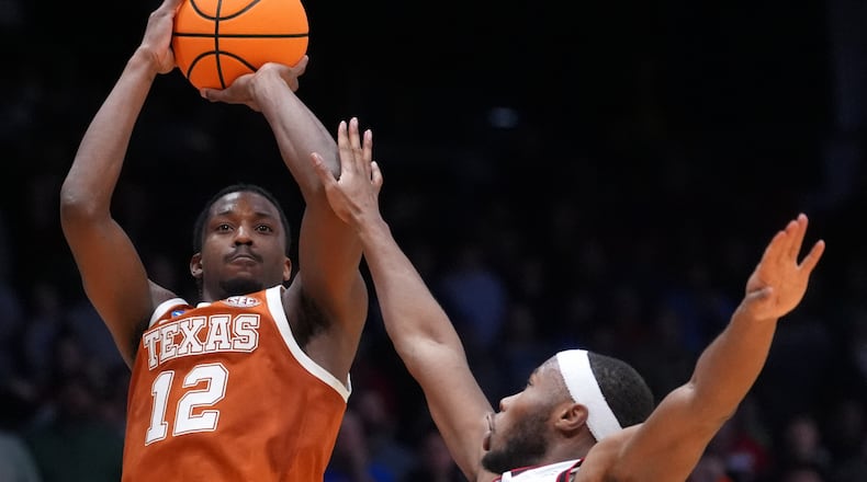 Texas guard Tramon Mark (12), left, scores a go-ahead basket with 1 second remaining during the second half in a First Four college basketball game in the NCAA Tournament against North Carolina State, Tuesday, March 17, 2026, in Dayton, Ohio. (AP Photo/Kareem Elgazzar)