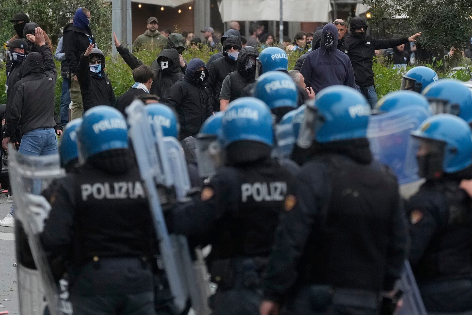Lazio fans clash with Italian Policemen in riot gear outside the olympic stadium prior to the start of the Italian Serie A soccer match between Lazio and Roma in Rome, Sunday, April 13, 2025. (AP Photo/Gregorio Borgia)
