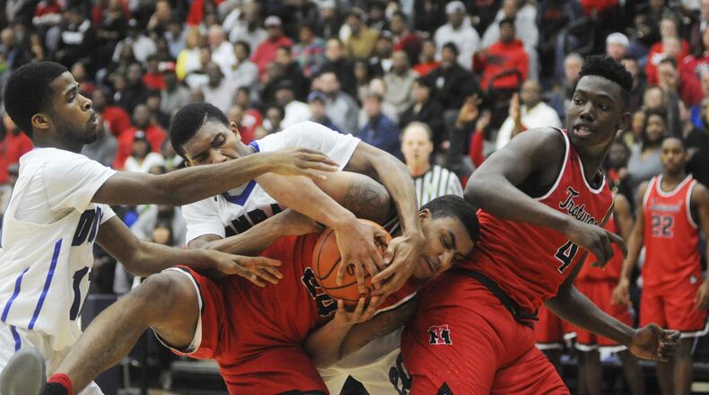 Trotwood’s Torrey Patton (with ball) and temmate Myles Belyeu (right) draw Dunbar defenders Sh’Mari Jamison (left) and Devon Baker. Trotwood-Madison defeated Dunbar 83-54 in a boys high school basketball D-II regional final at Fairmont’s Trent Arena on Saturday, March 18, 2017. MARC PENDLETON / STAFF