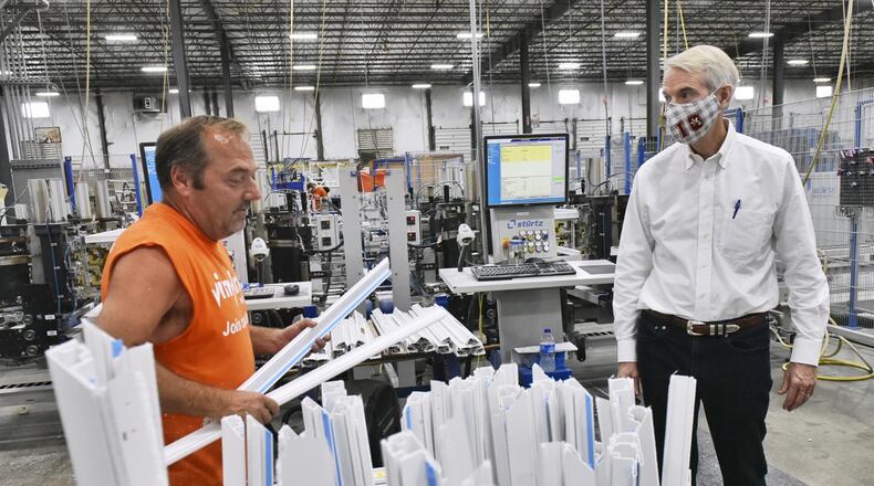 U.S. Sen. Rob Portman, R-Cincinnati, talks with 20-plus year Vinylmax Windows employee James Miller as he tours the Hamilton plant Monday, August 31, 2020. Vinylmax is one of the local business who received a payroll protection program loan to keep their employees on payroll during the COVID-19 pandemic. NICK GRAHAM/STAFF