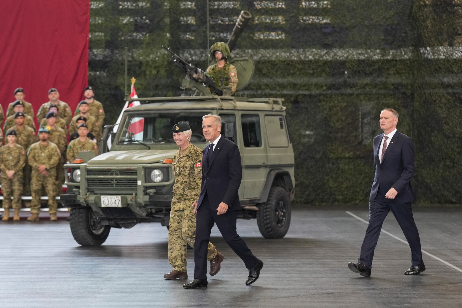Canada Prime Minister Mark Carney walks Chief of the Defence Staff, General Jennie Carignan and Minister of National Defence David McGuinty, right, as he prepares to make an announcement at Fort York Armoury in Toronto, Canada, on Monday, June 9, 2025. (Chris Young/The Canadian Press via AP)